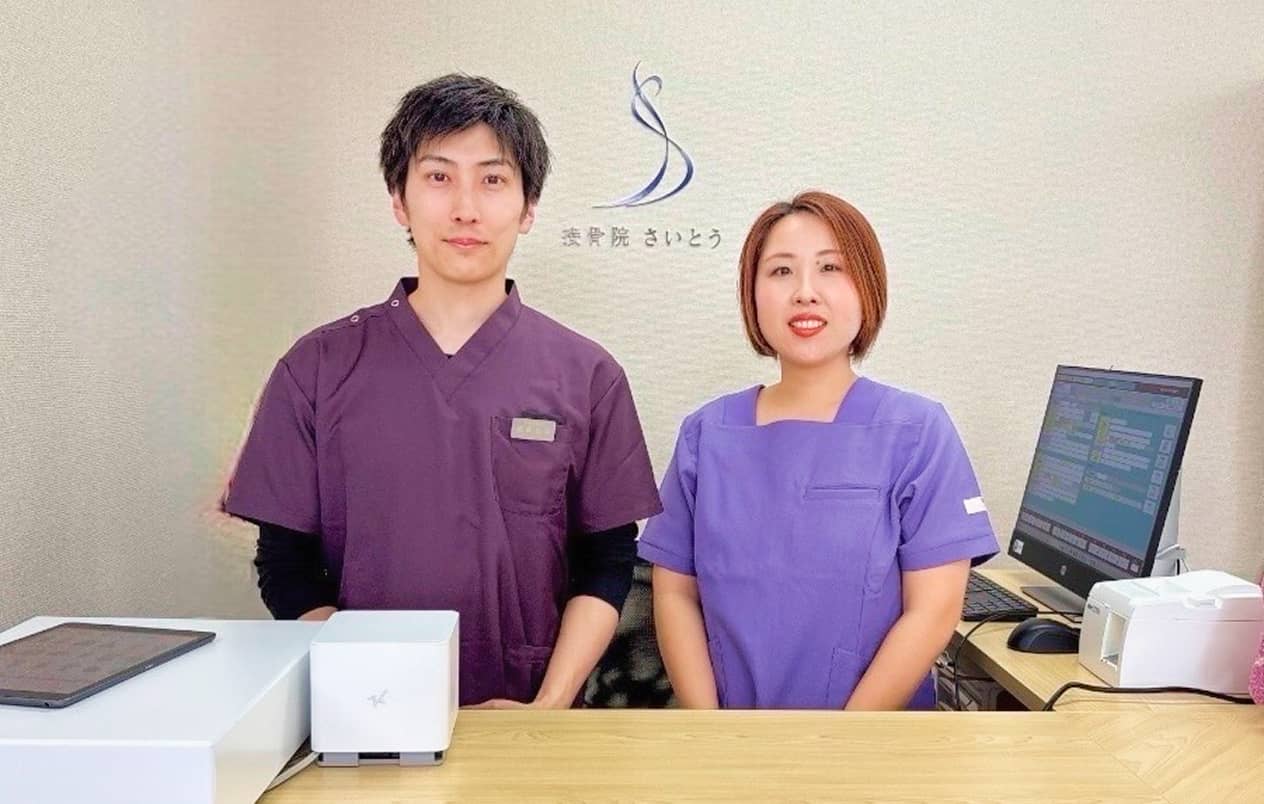 受付カウンターに立つスタッフ2人の写真