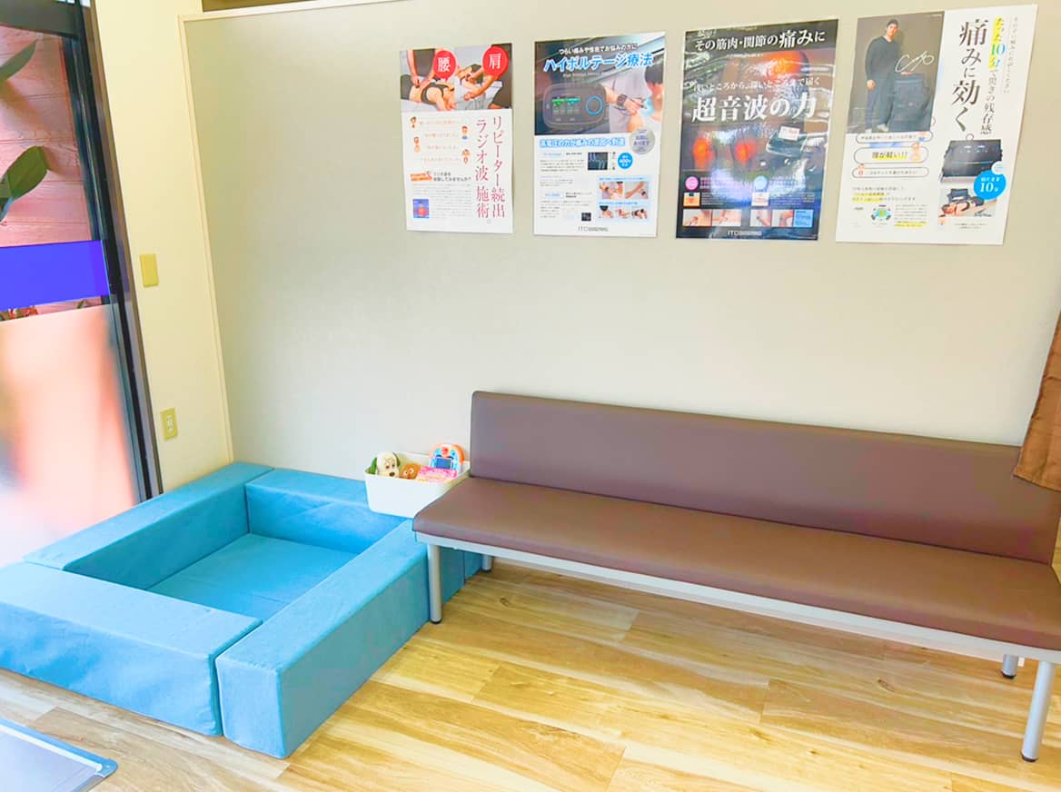 壁にポスターが貼られた待合室とソファ