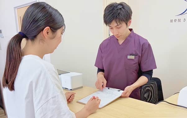 受付で問診票を記入する様子