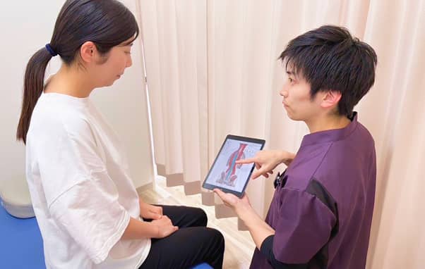 タブレットを使いながら治療方法の説明する診察の様子